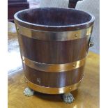 A MODERN OAK AND BRASS BOUND BUCKET SHAPED RECEIVER with brass lion mask and ring handles and paw