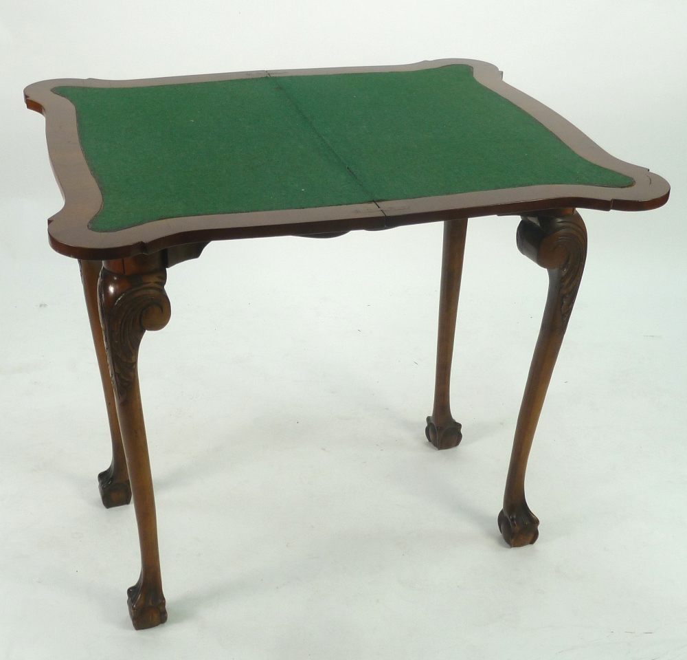 GEORGE II STYLE CROSSBANDED WALNUTWOOD CARD TABLE, the fold over shaped oblong top with green