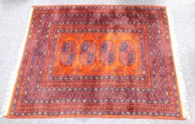 TURKOMAN RUG with three large stencilled black octagonal guls on a crimson field with broad border