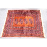 TURKOMAN RUG with three large stencilled black octagonal guls on a crimson field with broad border