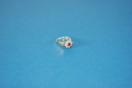 18cT GOLD RUBY AND DIAMOND DAISY CLUSTER RING, set with a circular centre ruby approx 5mm