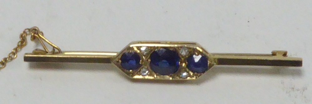 EDWARDIAN 9ct GOLD BAR BROOCH, the pointed oblong centre set with three round sapphires and two