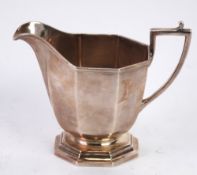 GEORGE V ART DECO SILVER CREAM JUG, of heavy gauge, of panelled form with angular scroll handle