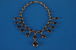 AN EDWARDIAN UNMARKED POSSIBLY 15ct gold NECKLACE set with thirty five graduated cabochon garnets,