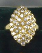 18ct GOLD RING, with a marquise shaped four tier cluster of forty three small uniform round