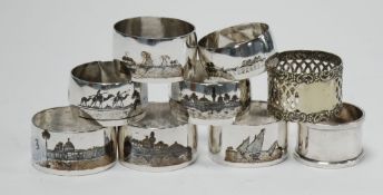SEVEN CAIRO WORK AND NEILLO DECORATED WHITE METAL NAPKIN RINGS, including a SET OF FOUR and two
