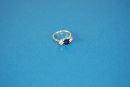 18ct GOLD AND PLATINUM RING, set with a centre square cut sapphire, 5mm wide, and two side round