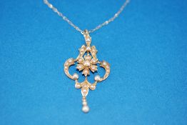 EDWARDIAN 15ct GOLD AND SEED PEARL PENDANT, of openwork scroll pattern with floral centre and