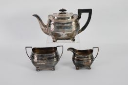 GEORGE V SILVER THREE PIECE TEA SET, of rounded oblong form with reeded girdle, black angular scroll