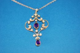 EDWARDIAN GOLD COLOURED METAL OPEN SCROLLWORK PENDANT, set with seed pearls, with collet set centre,