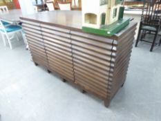 A MAHOGANY SIDEBOARD, WITH RIBBED EFFECT FRONT AND SIDES, FOUR DRAWERS TO CENTRAL SECTION, FLANKED