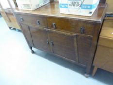 1930's OAK SIDEBOARD WITH TWO DRAWERS OVER TWO CUPBOARD DOORS, THE LOW BACK WITH SMALL MIRROR