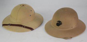 TWO PITH HELMETS, one with American Marine Corps badge, the other Vietnamese