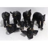 SIX INDIAN EBONY GRADUATED ELEPHANTS WITH IVORY TUSKS, also a pair of matching wall masks all dating