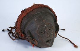 CHOKWE CARVED WOOD FEMALE DANCE MASK, with scarification, copper earrings and braided fabric on