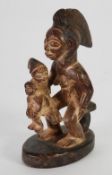 PUNU CARVED WOOD MATERNITY GROUP, modelled seated with a child and baby on her knee, the mother