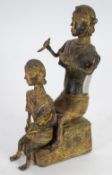 PROBABLY AFRICAN CAST BRONZE OR BRASS CEREMONIAL GROUP, modelled as two ladies seated, one holding a