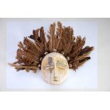 LEGA CARVED IVORY LUKUNGU MASK, with surround of cowrie shells and brown feathers, the mask, 4 ½"