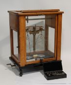 AN EARLY 20TH CENTURY L.OERTLING LTD London laboratory balance in glazed case, with a box of