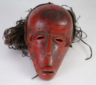 ANGOLA TYPE CARVED WOOD MASK, with red pigment and natural fibre wig, 10" (25.4cm) high