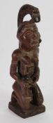 REPUBLIC OF CONGO CARVED WOOD MATERNITY FIGURE, modelled seated, feeding a baby from a large cup,