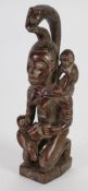 REPUBLIC OF CONGO CARVED WOOD MATERNITY FIGURE, modelled seated, feeding a baby from a large cup,