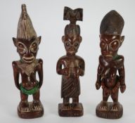 TWO YORUBA CARVED WOOD IBEJI FIGURES, with beadwork necklaces, and another, similar maternity