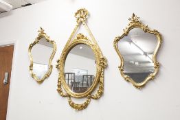 A GILT FRAMED OVERMANTEL MIRROR, FRENCH STYLE WITH OVAL GLASS, RIBBON AND BOW FRAME AND A PAIR OF