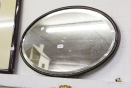 AN OVAL BEVELLED EDGE WALL MIRROR, IN WOODEN FRAME