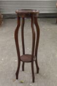 A VICTORIAN MAHOGANY JARDINIERE STAND, CIRCULAR TOP ON SQUARE FLUTED SUPPORTS AND UNDERTIER