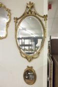 A GILT FRAMED WALL MIRROR, WITH RIBBON DETAILS AND A SMALLER EXAMPLE (2)