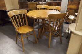 A PINE CIRCULAR DINING TABLE AND FOUR CHAIRS