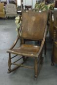 AN OAK ROCKING CHAIR WITH PLY PANEL SEAT AND BACK