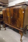 A MODERN FLAME MAHOGANY TELEVISION CABINET, SOLID DOORS WITH LINE INLAY ON CABRIOLE SUPPORTS