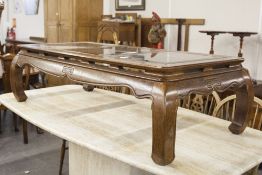 A LARGE CHINESE HARDWOOD OBLONG COFFEE TABLE WITH GLASS INSET TOP