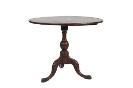 A GEORGE III MAHOGANY CIRCULAR TILT-TOP TEA TABLE, the one-piece top above a baluster column and