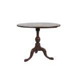 A GEORGE III MAHOGANY CIRCULAR TILT-TOP TEA TABLE, the one-piece top above a baluster column and