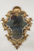 MODERN ROCOCO STYLE GILT FLANKED WALL MIRROR, the shaped plate in an ornate scrollwork frame with