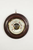 EARLY TWENTIETH CENTURY ANEROID BAROMETER in turned mahogany stained carved fruitwood surround, 13