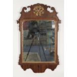 GEORGE III MAHOGANY AND PARCEL GILT WALL MIRROR, the oblong plate in a moulded frame with pierced