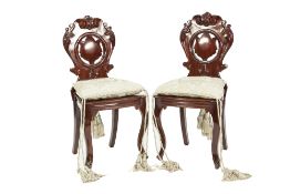 PAIR OF NINETEENTH CENTURY CARVED MAHOGANY HALL CHAIRS, each with circular pierced central panel and