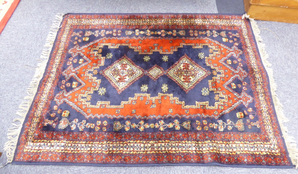 EASTERN RUG, with triple diamond pattern, pole medallion, on a dark blue field with irregular red,