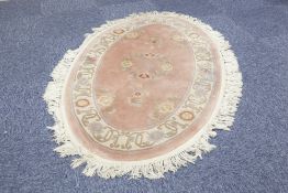 PAIR OF WASHED CHINESE ALL WOOL OVAL RUGS with an embossed circular centre floral medallion and