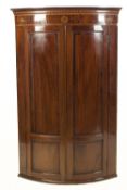 GEORGE III INLAID MAHOGANY BOW FRONTED CORNER CUPBOARD, the moulded cornice above a frieze inlaid