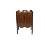 GEORGIAN MAHOGANY BEDSIDE CABINET, the oblong top with cut out handles to the wavy gallery, above