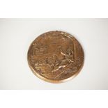 EMBOSSED GILT METAL CIRCULAR PLAQUE, decorated with a religious scene depicting a reclining