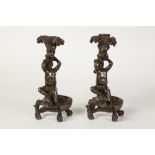 PAIR OF BRONZE FIGURAL CANDLE HOLDERS, each cast as nude cherubs sat on the back of a crocodile, 8