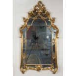 MODERN ROCOCO STYLE GILT FRAMED WALL MIRROR, the arched, oblong plate in an ornate moulded frame