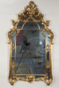 MODERN ROCOCO STYLE GILT FRAMED WALL MIRROR, the arched, oblong plate in an ornate moulded frame