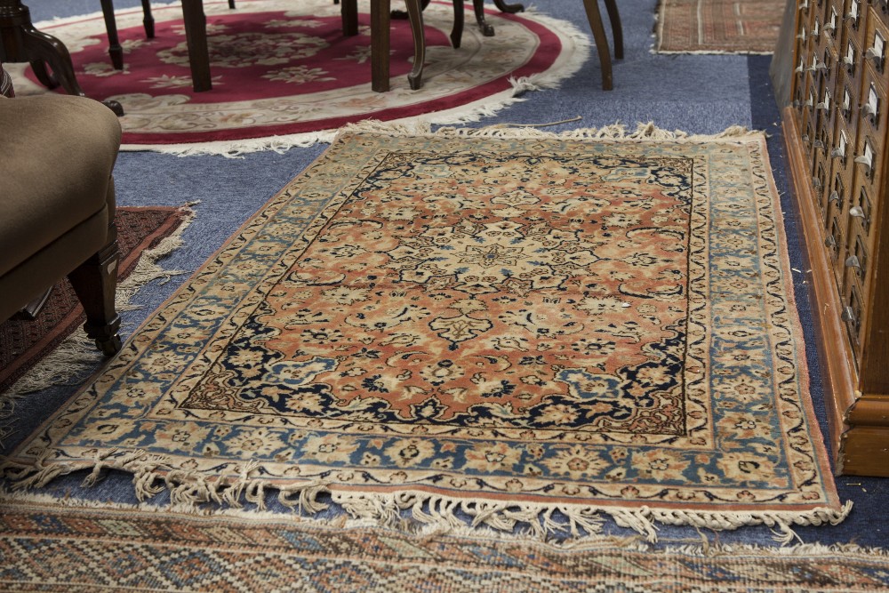 FINELY KNOTTED KIRMAN RUG, with star shaped centre medallion with pendants on a pink field scattered